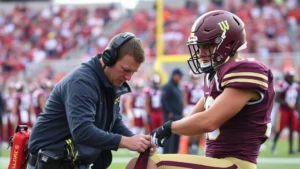Athletic trainer assessing injured football player on sideline during college game, medical equipment visible, intense focus and professionalism