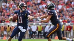 College football quarterback executing precise handoff to running back during intense game action, stadium crowd blurred in background, dynamic athletic movement captured mid-play