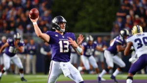 Washington Huskies quarterback throwing football downfield in purple uniform during intense competitive game with excellent form and focus