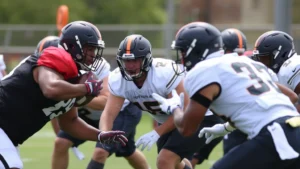 College football players executing defensive gap assignments during practice, wearing full pads and helmets, demonstrating disciplined positioning and communication with clear focus and intensity